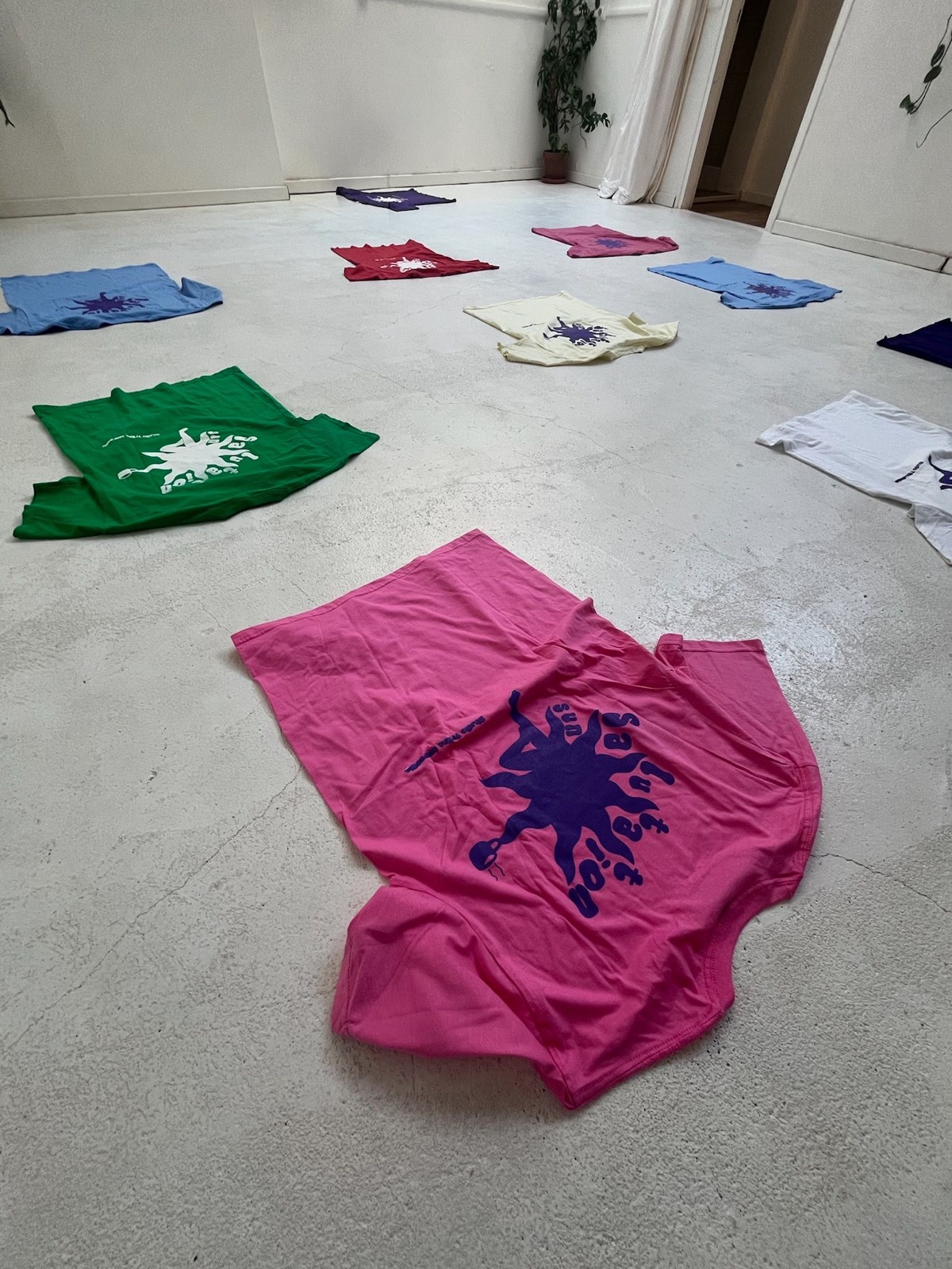 Collection de tee-shirts sérigraphiés posés au sol